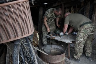Украинские военные пытаются починить миномет калибра 120 мм, вышедший из строя после очередного выстрела (здесь и далее место съемки и другие данные не раскрываются по соображениям безопасности — прим. «Медузы»)