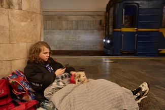 16-летний Лео и его собака второй день спят на станции метро в Киеве вместе с семьей и другими горожанами. 25 февраля 2022 года