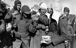Советские солдаты раздают хлеб немецким военнопленным после Сталинградской битвы, 1942 год