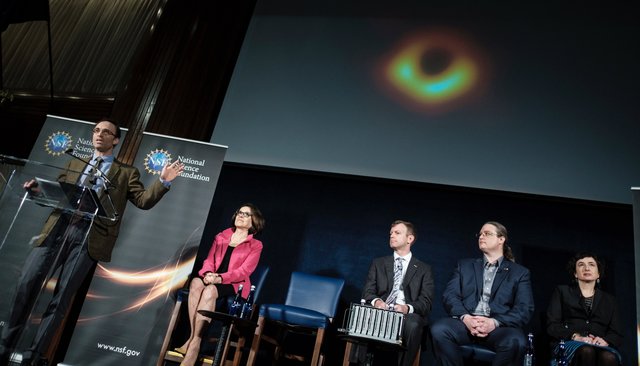 Директор проекта «Телескоп горизонта событий» Шеперд Доулман представляет первое изображение черной дыры. 10 апреля 2019 года