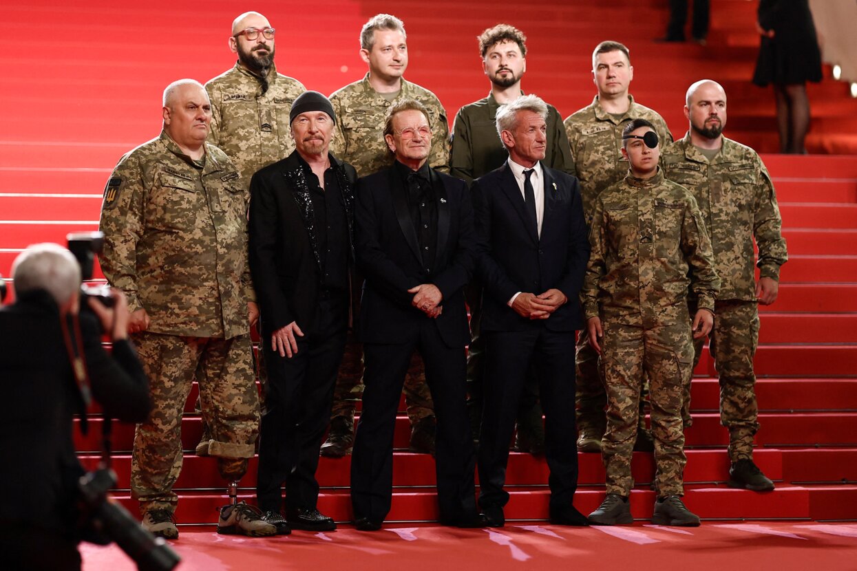 Боно и бойцы ВСУ на красной дорожке в Каннах. Фотография — Meduza