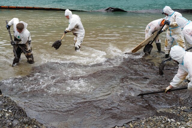 В Туапсе чистят море от нефти — на фоне дыма от очередного пожара. Вот как это выглядит