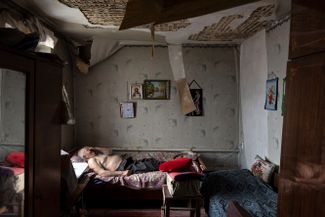 85-летний Алексей Пшеничных отдыхает в своем поврежденном в ходе войны доме в Ольховке, которая до недавнего времени была оккупирована российскими войсками