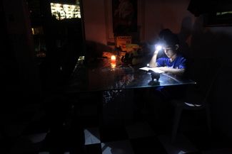 Из-за отсутствия электричества многим приходится читать с помощью фонариков. Пуэрто-Рико, 28 сентября 2017 года
