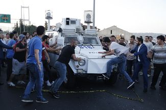 Демонстранты раскачивают полицейский бронеавтомобиль с задержанными мятежниками, Стамбул