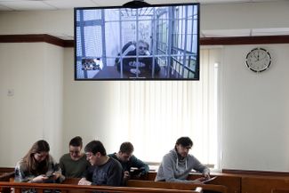 Дмитрий Богатов (на мониторе) во время рассмотрения законности его ареста в Мосгорсуде, 25 апреля 2017 года