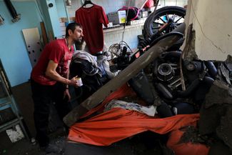 Харьковчанин Сергей Савич осматривает свой мотоцикл Harley-Davidson, поврежденный в ходе бомбардировки