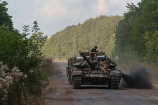 Бойцы ВСУ, вернувшиеся на территорию Украины, везут дорожный указатель, стоявший на въезде в село Любимовка Курской области. Сумская область, приграничье