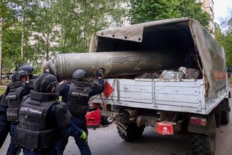 Сотрудники ГСЧС Украины убирают обломок российской ракеты от ЗРК С-300, выпущенной войсками РФ по Харькову