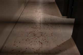 Кровь на полу в подъезде жилого дома, где во время российской атаки пострадал мирный житель