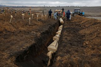 Братская могила, в которой хоронят погибших на войне. Поселок Старый Крым рядом с Мариуполем в аннексированной ДНР. Февраль 2023 года