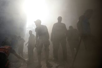 Палестинские спасатели ищут выживших при авиаударе по городу Хан-Юнис. 6 ноября 2023 года