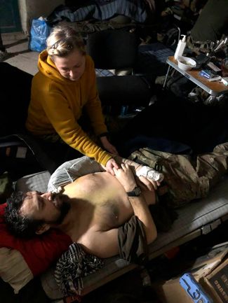 Женщина ухаживает за раненым на заводе «Азовсталь» в Мариуполе. Апрель 2022 года