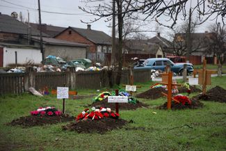 Могилы погибших рядом с жилыми домами в Мариуполе. 13 апреля 2022 года