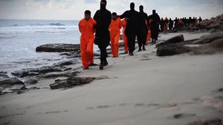 Люди в оранжевом, скорее всего, египетские христиане, задержанные бойцами ИГ. Скриншот сделан с видео, выпущенного ИГ 15 февраля 2015 года