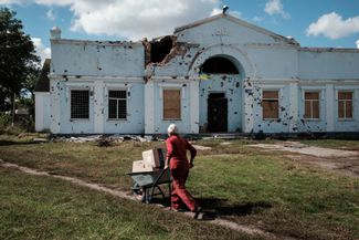 Местный житель в селе Лебяжьем Харьковской области с гуманитарной помощью ООН 22 сентября 2022 года. Каждая коробка весом 12 килограммов содержит запас продуктов на месяц для одного человека. До сентября, когда украинские войска начали контрнаступление, Лебяжье находилось на линии фронта