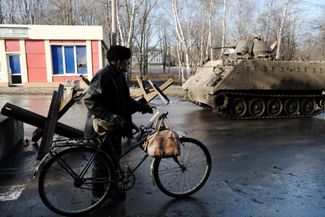 Житель Бахмута рядом с украинской военной техникой на одной из улиц города