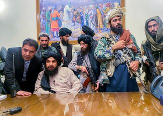 Бойцы «Талибана» фотографируются в афганском президентском дворце после захвата всей территории страны и бегства президента Ашрафа Гани. 15 августа 2021 года