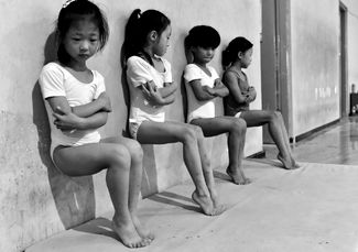 Категория «Повседневная жизнь», второе место в номинации «Отдельная фотография». Учащиеся школы гимнастики в Китае выполняют 30-минутное упражнение для укрепления пальцев ног.<br>
