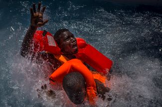 Категория «Срочные новости», третье место в номинации «Фотоистория». Спасатели достают из воды беженцев, переплывавших Средиземное море. По данным ООН, в 2016 году более 3500 человек погибли в море, пытаясь добраться до Европы