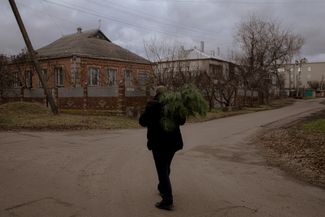 Serhii, a resident of Mala Rohan, carries a Christmas tree home. December 31, 2023.