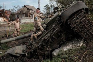 Украинские военные возле российского танка в освобожденной Кирилловке