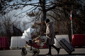 Девушка с маленьким ребенком в районе румынского города Сирет, недалеко от румыно-украинской границы. 25 февраля 2022 года