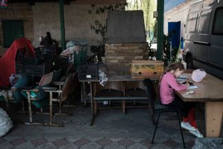 9-летняя Саша, дочь капеллана Олега, делает уроки со смартфоном. С начала войны она на онлайн-обучении