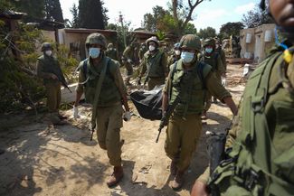 Всего в Израиле во время нападения боевиков ХАМАС погибли, по данным на 11 октября, более 1200 человек. Военнослужащие ЦАХАЛ несут тело одного из жителей Кфар-Аза, убитого во время нападения террористов. 10 октября 2023 года