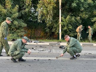Следователи работают на месте взрыва автомобиля, за рулем которого была Дарья Дугина. Одинцовский район Московской области, 21 августа 2022 года