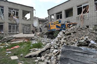 Спасатели разбирают завалы здания школы, уничтоженной российским ракетным ударом. В результате обстрела Харьковской области 28 июня погибли двое местных жителей