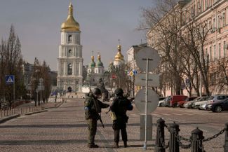 Украинские военнослужащие стоят на контрольно-пропускном пункте в Киеве