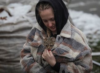 Девушка из Вышгорода выносит котенка из дома, разрушенного в результате российской ракетной атаки