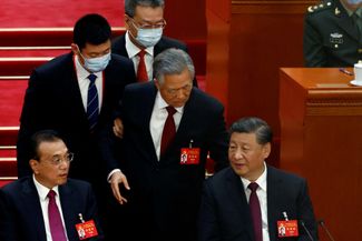 Самый резонансный момент съезда: бывшего генсека КПК Ху Цзиньтао (в центре) принудительно выводят из Зала народных собраний