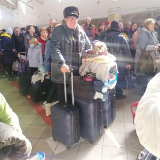 Отец Ларисы в центре размещения беженцев после 15 часов на границе между Польшей и Украиной с вещами, Тосей и переноской, в которой сидит Нора