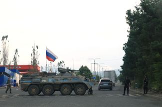 Азербайджанская полиция и российские миротворцы на блокпосту у въезда в Степанакерт. 2 октября 2023 года
