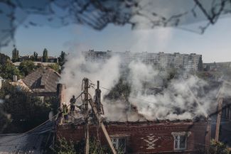 Пожарные после обстрела тушат дом в Бахмуте Донецкой области, который находится недалеко от линии фронта
