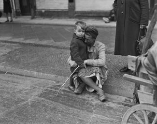 Женщина утешает сына среди разрушений послевоенной Германии. Берлин, июнь 1945 года