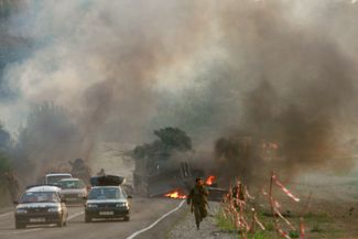 Грузинские военнослужащие бегут от горящего бронетранспортера по дороге, ведущей к Тбилиси. 11 августа 2008 года 