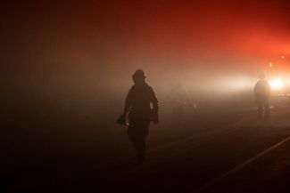 Пожарные идут к одному из очагов возгорания в округе Плюмас, 24 июля 2021 года