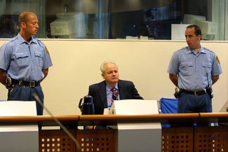 Бывший президент Сербии Слободан Милошевич на скамье подсудимых в Международном трибунале по бывшей Югославии в Гааге. 30 августа 2001 года