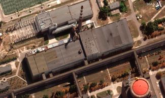 Новый спутниковый снимок Maxar Technologies. На нем видны следы ракетных ударов по крыше одного из зданий. Украина и Россия (контролирующая территорию АЭС) обвиняют в обстрелах друг друга. 