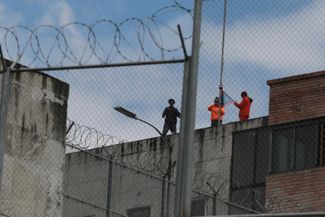 Заключенные стоят на крыше тюрьмы Тури в Куэнке во время бунта. 9 января 2024 года
