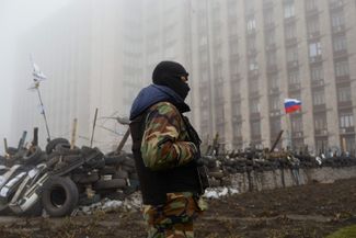 A Russia-backed militiaman stands guard outside the seized government building in Donetsk. April 15, 2014.