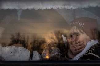 Женщина с ребенком в автобусе в колонне, прибывшей в Запорожье из Мариуполя и Мелитополя