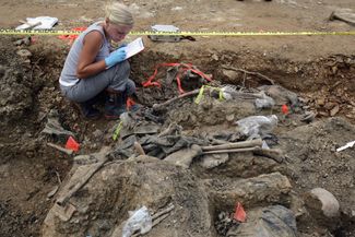 Канадский археолог-криминалист Рене Косалка работает на месте раскопок братской могилы жертв геноцида в Сребренице в боснийской местности Будак. Здесь перезахоронены около 100 тел из другой, более крупной могилы. Босния и Герцеговина, 12 июня 2005 года 