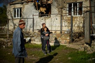 Жители села Шандриголово под Лиманом возле своего разрушенного российскими ударами дома 