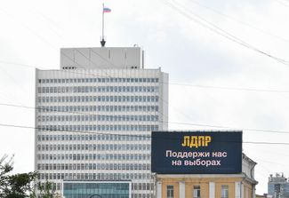 An LDPR campaign poster next to a Primorsky Krai government building