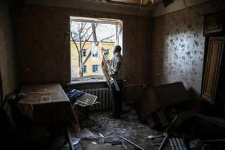 Житель находящегося под контролем Украины Краматорска разбирает завалы в своей разрушенной квартире