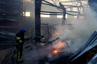 Киевские пожарные тушат возгорание после попадания российской ракеты в складское помещение
